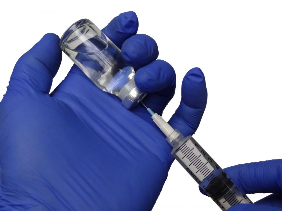 picture of a gloved hand extracting a vaccine from a vial