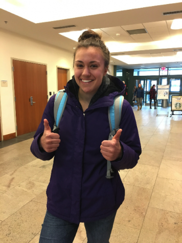 A student grins with two thumbs up