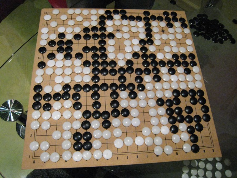 The board for the game Go, with circular black and white pieces on a grid